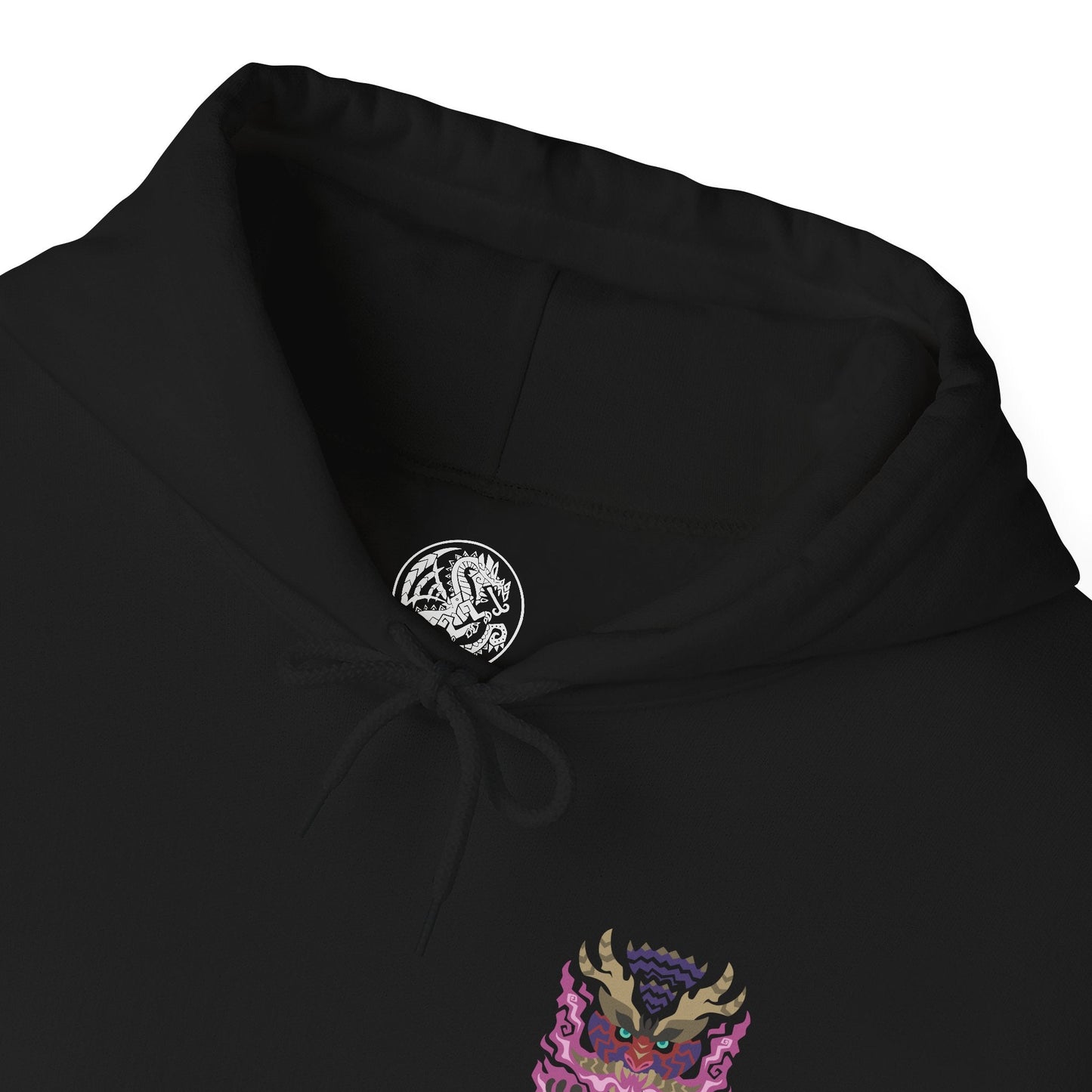 Folded Hooded Sweatshirt of Scorned Magnamalo roaring beneath a storm-dark sky, crimson Hellfire pouring from its armored body as jagged spikes and its massive bladed tail dominate the battlefield. Smoke, ash, and burning debris surround the fearsome predator while its glowing eyes lock onto unseen prey. The composition emphasizes raw power, savage determination, and the legendary presence of one of Monster Hunter's most fearsome flagship monsters.