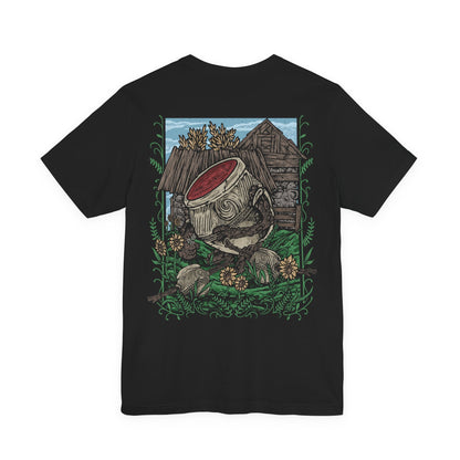 Image 5 of a T-Shirt artwork depicting Alexander the Warrior Jar resting among the tranquil gardens of Jarburg, surrounded by colorful flowers, smaller Living Jars, and lush vegetation. Despite his imposing warrior reputation, the peaceful setting reveals a gentler side of the famous jar warrior. This design reflects Alexander's love of battle, his determination to grow stronger, and his unforgettable journey across the Lands Between.