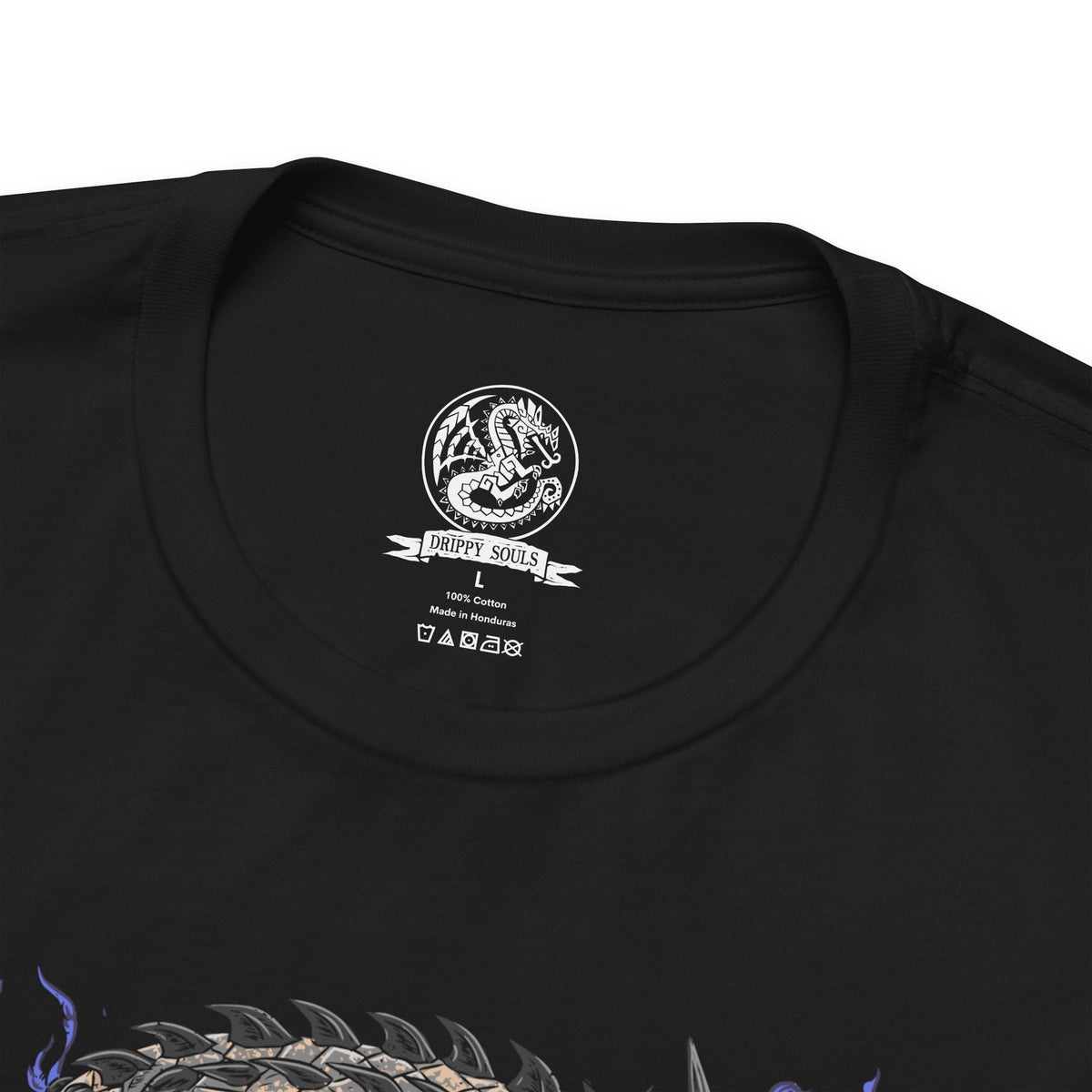 Folded T-Shirt design of Dalamadur from Monster Hunter 4 Ultimate, depicting the colossal black serpentine Elder Dragon coiling around towering mountain peaks beneath a storm-filled sky. Its enormous fanged head rises above the landscape while its long body winds through the rocky battlefield. The artwork emphasizes Dalamadur's immense scale, ancient power, and terrifying presence.
