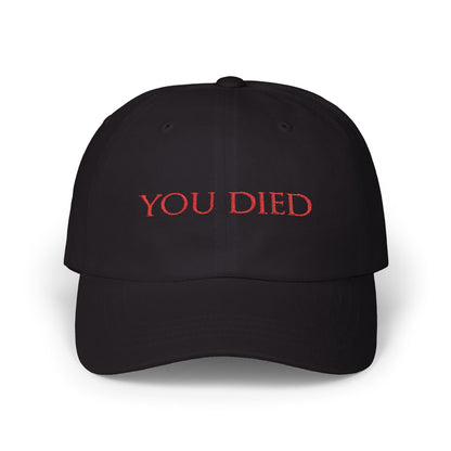 Image 3 of a Black Embroidered Cap featuring the iconic “You Died” screen from Dark Souls, a legendary meme recognized by gamers worldwide. Displayed in bold red text over a black backdrop, this phrase symbolizes brutal difficulty, hard-earned lessons, and countless player deaths. A perfect design for fans who wear their defeats with pride and humor.