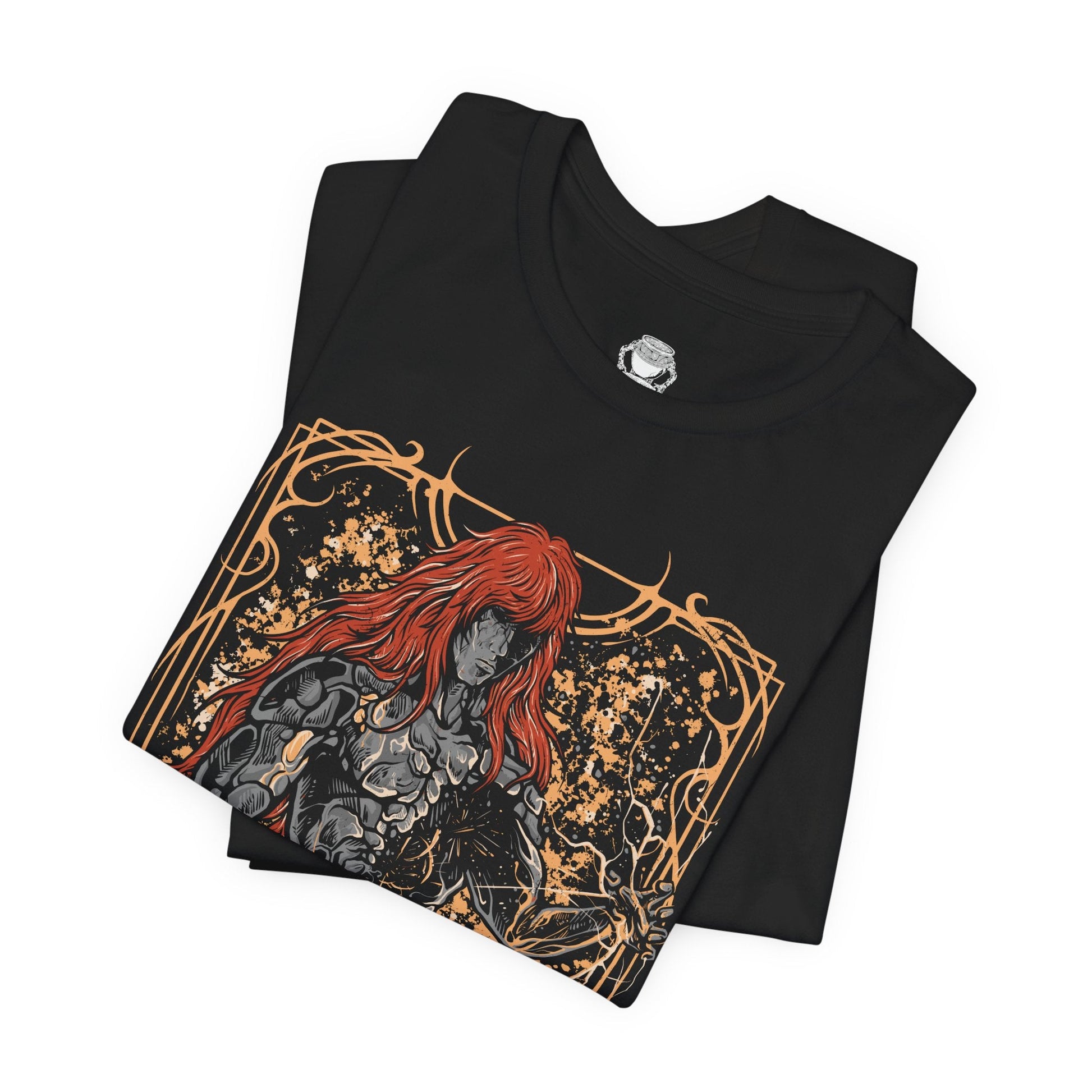 Folded T-shirt featuring Radagon of the Golden Order from Elden Ring, the divine champion and second Elden Lord. Both consort and counterpart to Queen Marika, Radagon embodies the perfection and tragedy of the Golden Order. This design captures his radiant red hair, golden rune magic, and divine form—symbolizing faith, conflict, and the duality of godhood and guilt.