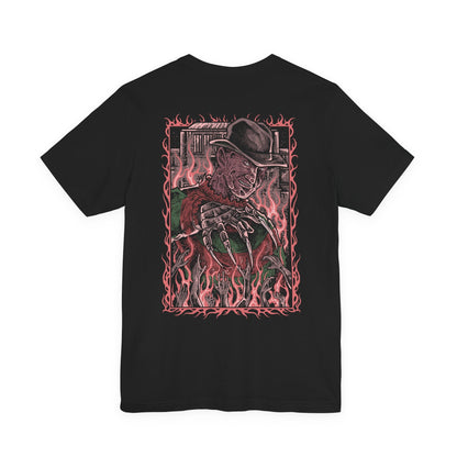 Image 5 of a T-Shirt artwork depicting Freddy Krueger standing inside a distorted dreamscape where boiler room pipes, smoke, and flickering flames surround his scarred figure. Razor-sharp claws glint under dim light as reality bends unnaturally around him. This design reflects Freddy’s power within dreams, embodying fear, manipulation, and the terror of never being safe even while asleep.