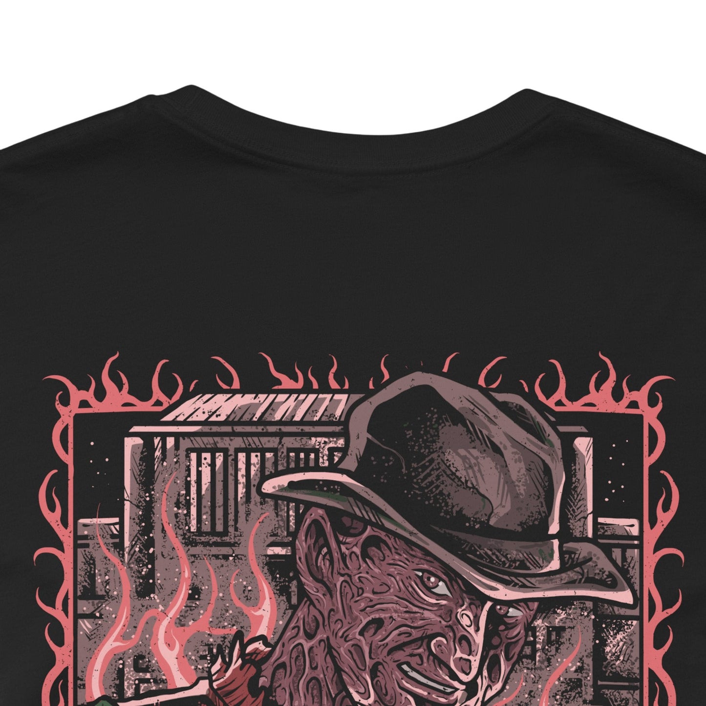 Image 7 of a T-Shirt artwork depicting Freddy Krueger standing inside a distorted dreamscape where boiler room pipes, smoke, and flickering flames surround his scarred figure. Razor-sharp claws glint under dim light as reality bends unnaturally around him. This design reflects Freddy’s power within dreams, embodying fear, manipulation, and the terror of never being safe even while asleep.