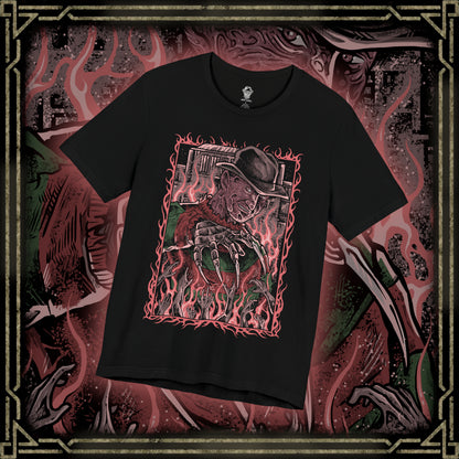 Thumbnail of a T-Shirt design of Freddy Krueger from A Nightmare on Elm Street, emerging from a nightmare-filled darkness with his bladed glove extended toward the viewer. His burned face twists into a sinister grin beneath a worn fedora while red and green stripes fade into shadow behind him. The design captures dreamlike terror, psychological horror, and the unstoppable fear haunting Elm Street.