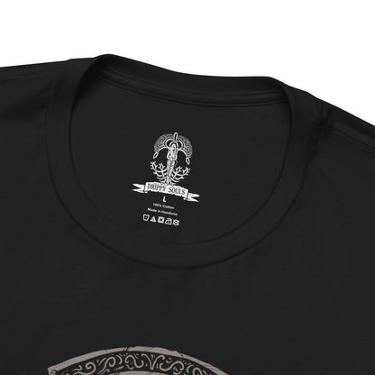 Folded T-Shirt design of Hoarah Loux from Elden Ring, the legendary warrior standing amid the ruins of Leyndell with his massive body covered in battle scars. Golden light and swirling ash surround him as he prepares to unleash his brutal grappling techniques. The design captures the primal strength of the warrior who once ruled as a fierce chieftain before becoming Godfrey, First Elden Lord.