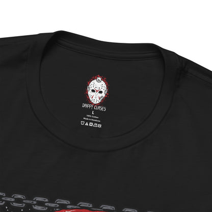 Folded T-Shirt design of Jason Voorhees from Friday the 13th, standing at the edge of Crystal Lake beneath a moonlit sky. His hockey mask reflects dim light as he grips a bloodstained machete, with trees and cabins fading into darkness behind him. The design captures the eerie silence of the camp and the unstoppable presence of a killer bound to the легенd of Crystal Lake.