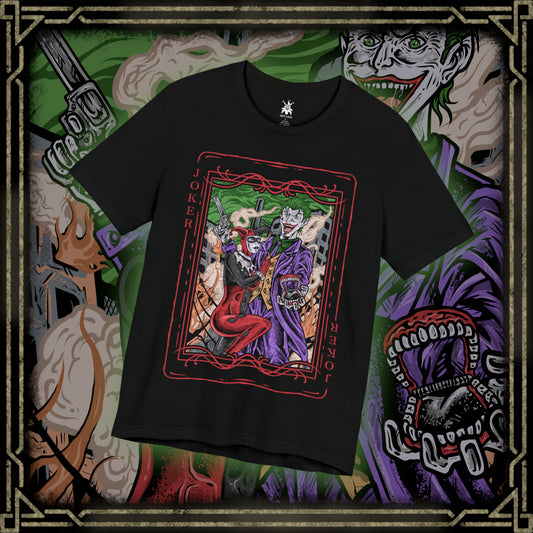 Thumbnail of a T-Shirt design of the Joker and Harley Quinn from DC Comics, standing amid a rain-soaked Gotham alley as playing cards, graffiti, and chaotic laughter surround them. The Joker’s sinister grin contrasts with Harley’s mischievous smile as she twirls her oversized mallet. The design captures their unpredictable partnership, anarchic romance, and the dangerous chemistry that has made them one of comic history’s most iconic villain duos.