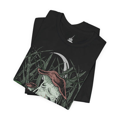 Image 5 of a T-Shirt design featuring the Mushroom People of Darkroot Garden from Dark Souls, standing among ancient trees, tangled roots, and thick forest mist. Their oversized mushroom-like bodies emerge from the shadows beneath the canopy while faint sunlight filters through the branches. The design captures the strange, peaceful, and unsettling atmosphere of Darkroot Garden and its mysterious inhabitants.