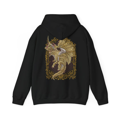 Image 5 of a Hooded Sweatshirt of Shagaru Magala standing atop ancient ruins beneath a luminous sky, golden scales shimmering as sacred-looking light and drifting Frenzy particles envelop the environment. Massive wings cast shadows across the land while the atmosphere itself seems transformed by its existence. The composition highlights majestic power, tragic evolution, and the awe-inspiring presence of one of Monster Hunter's most iconic Elder Dragons.
