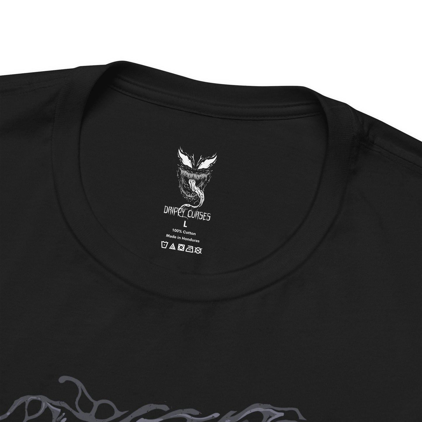 Folded T-Shirt design of Venom from Marvel, towering in darkness as the black symbiote stretches across his massive muscular body. Sharp teeth glisten beneath glowing eyes while his long tongue curls outward, dripping saliva onto cracked pavement below. The design captures Venom’s monstrous power, predatory nature, and the terrifying fusion between alien symbiote and human host.